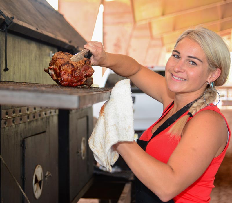 woman taking chicken out of oven
