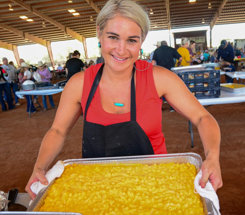 woman holding tray of mac and cheese